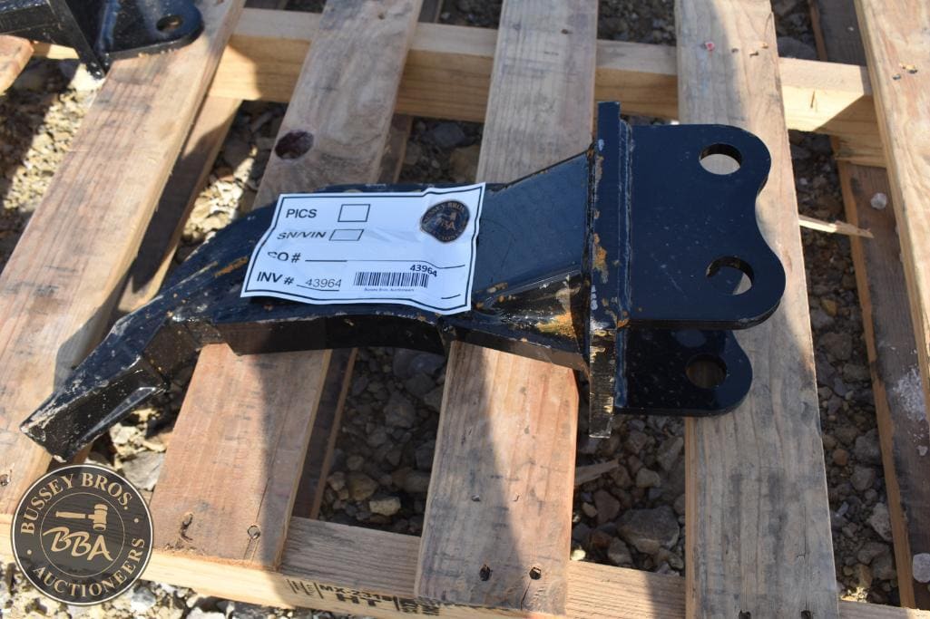 Heavy-duty black metal trailer hitch on wooden pallet.