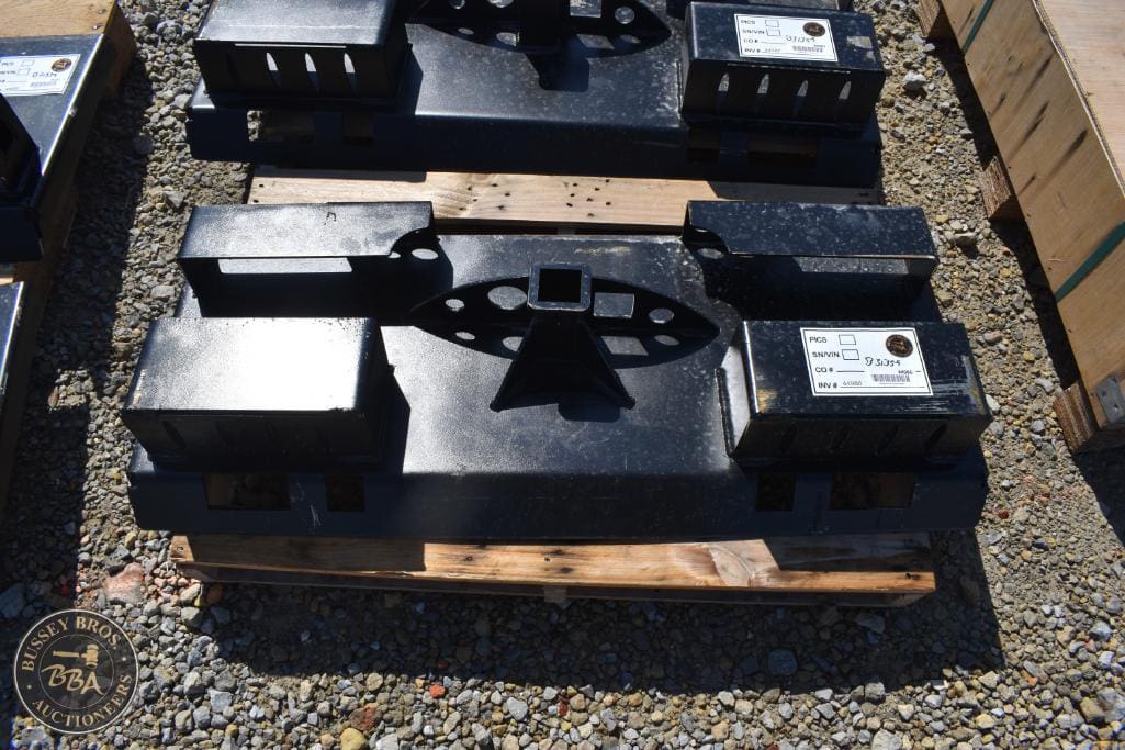 Heavy-duty black metal weights and equipment parts at auction.