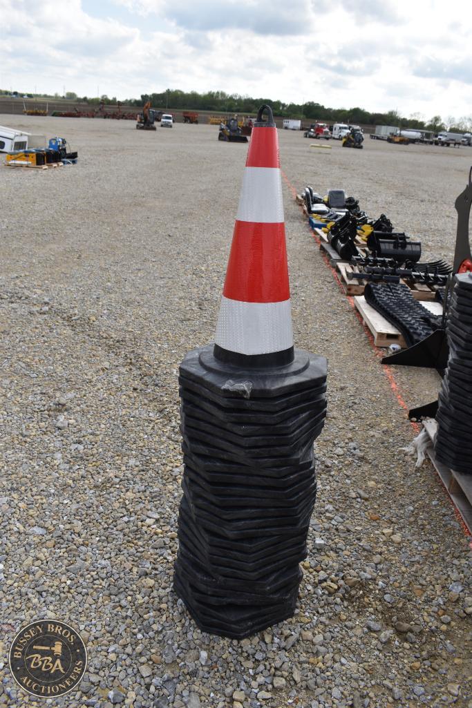 Traffic cone with rubber bases stacked at an outdoor auction yard.