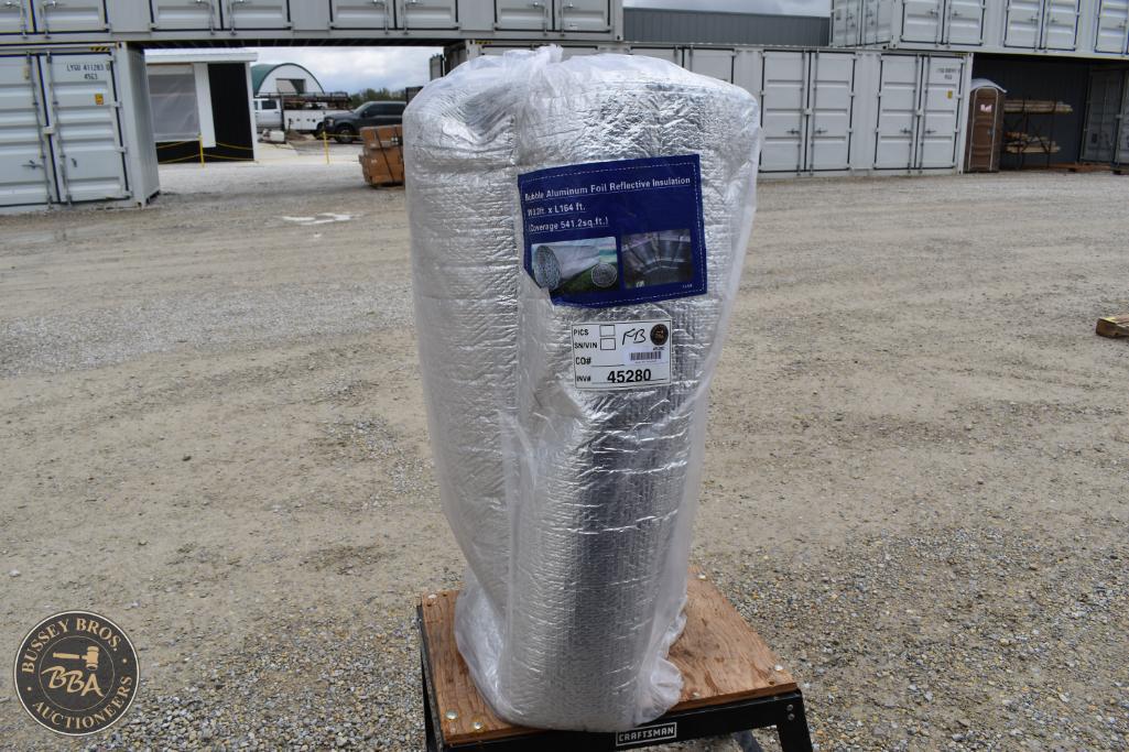 Insulated industrial pipe wrapped in reflective insulation at auction site.