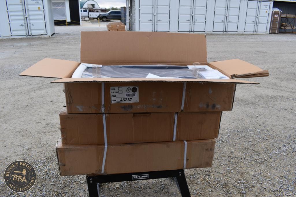 Auction equipment in open cardboard boxes at Bussey Bros Auctioneers.