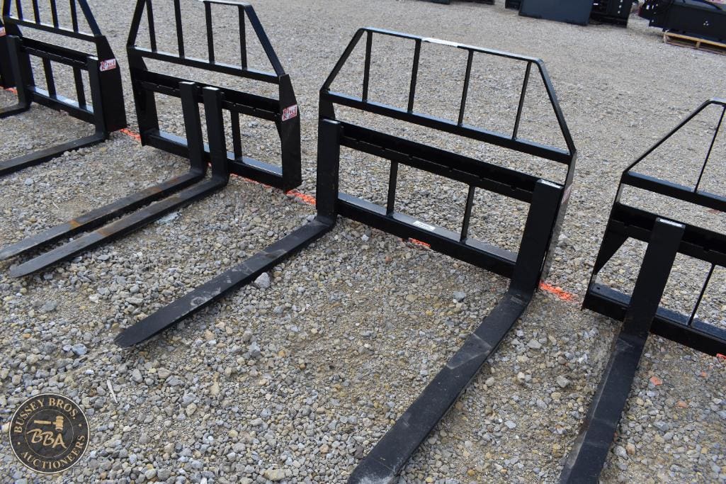 Forklift attachment forks with safety bars for material handling.