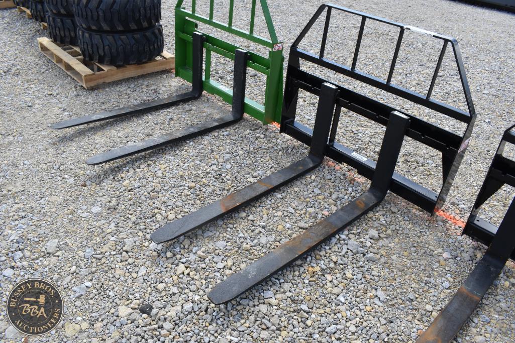 Forklift fork extensions and safety cages displayed outdoors.