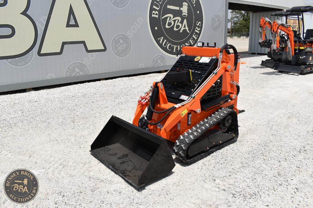Mini skid steer loader with black bucket and orange body, displayed outdoors at Bussey Bros Auctione.
