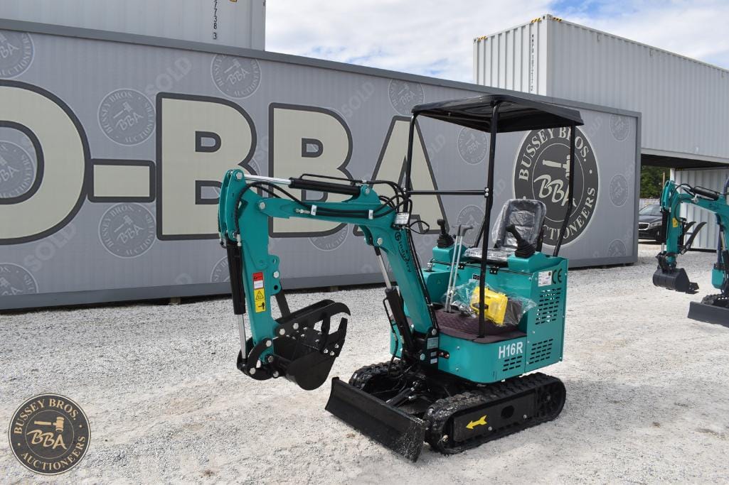 Compact teal mini excavator with black tracks at Bussey Bros Auctioneers.
