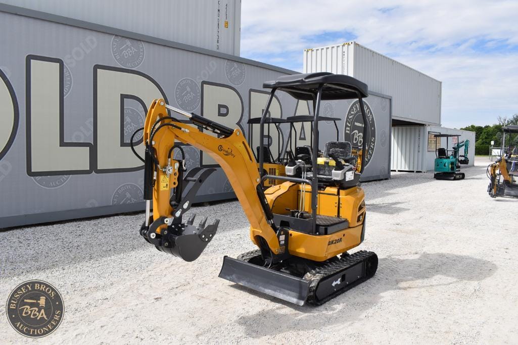 Compact yellow mini excavator with black tracks at Bussey Bros Auctioneers yard.