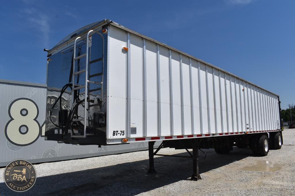 Heavy-duty white truck trailer with black ladder and support legs, ideal for commercial transport an.