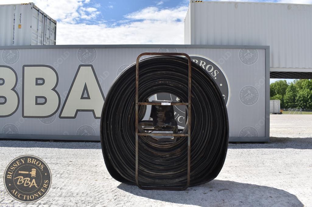 Coiled industrial hose at Bussey Bros Auctioneers outdoor lot.