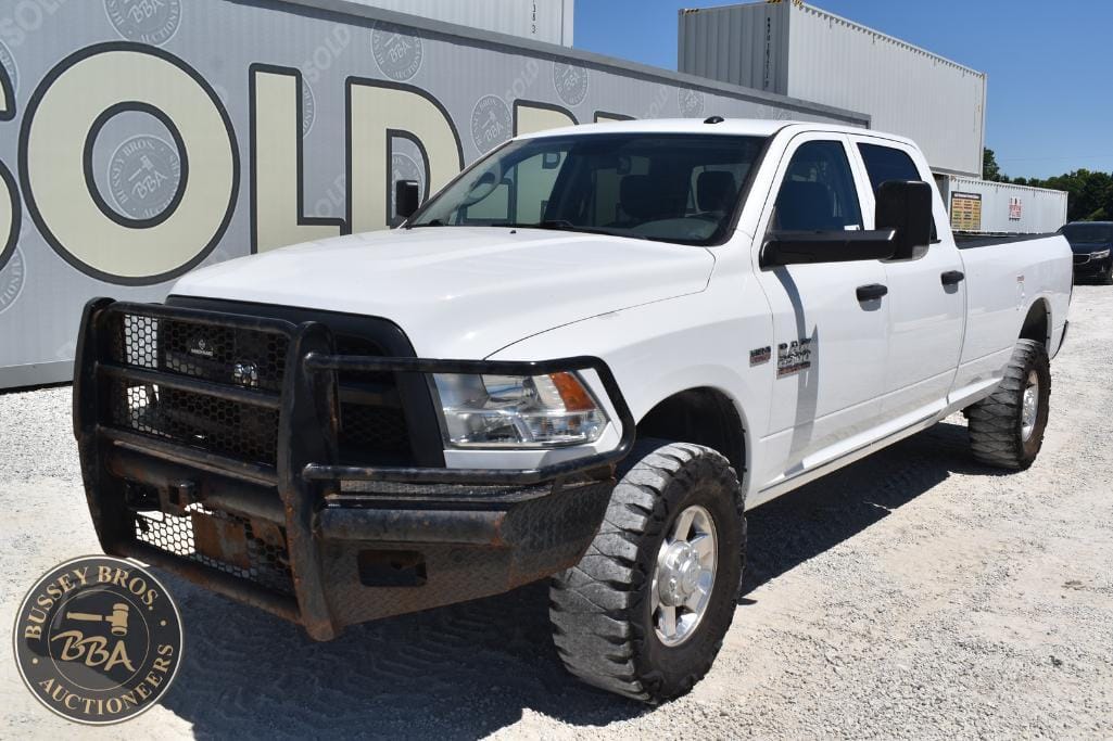 White pickup truck with black grille guard at Bussey Bros Auctioneers yard.
