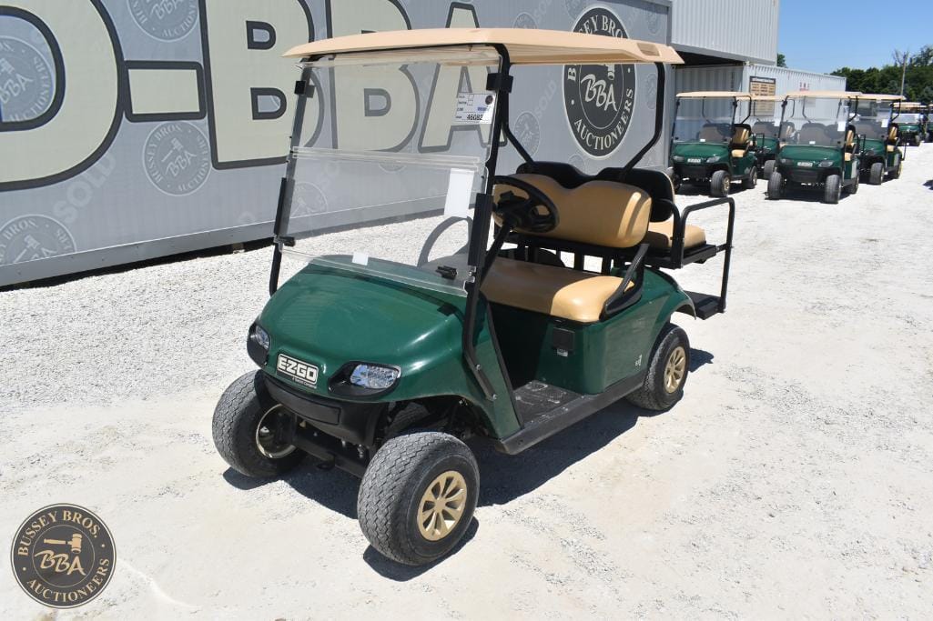Golf cart with beige seats and green body, ideal for golf courses or resort transport.