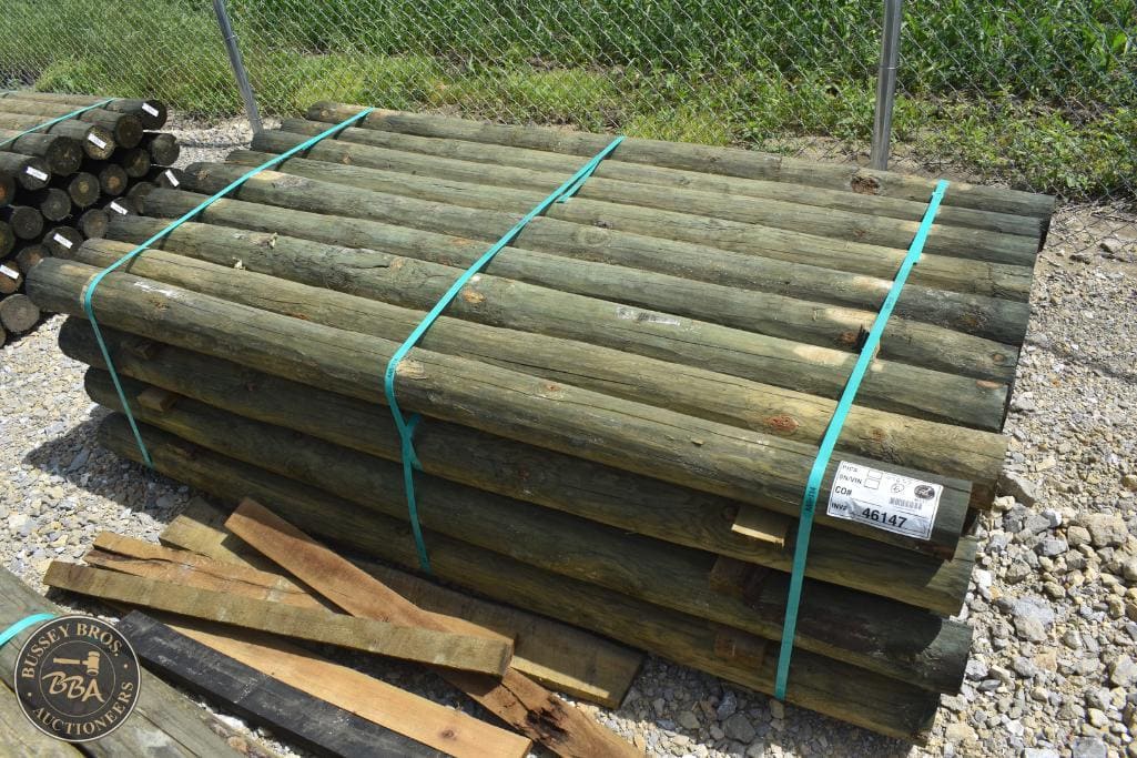 Wooden fence posts bundled for sale at Bussey Bros Auctioneers.