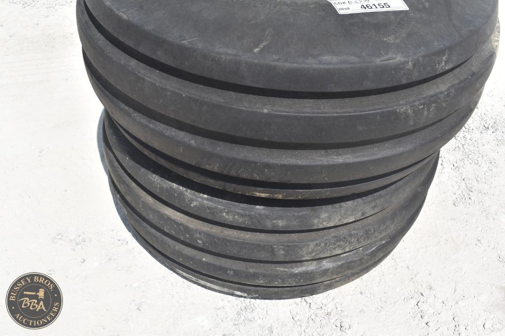 Stack of large black rubber weights for industrial or gym equipment, durable and heavy-duty.