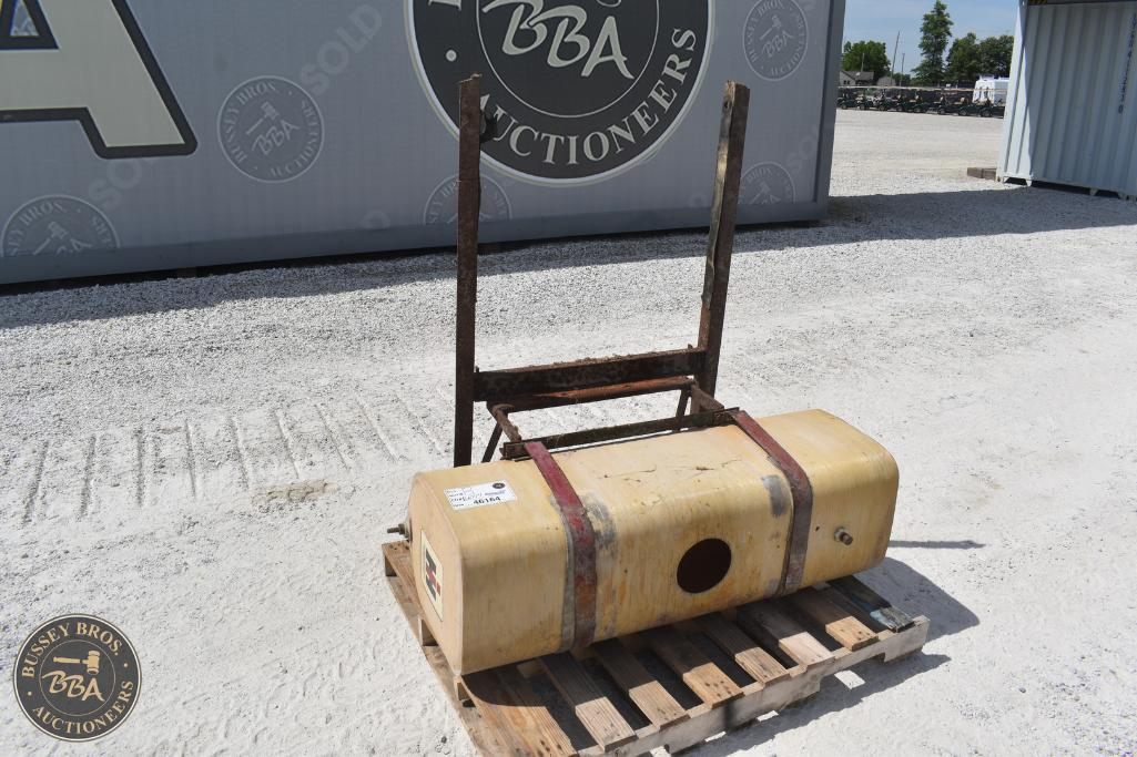 Fuel tank for farm machinery at auction site, mounted on wooden pallet for transportation and displa.