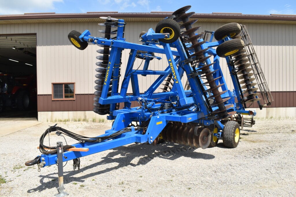 Blue farm implement for soil cultivation at auction site.