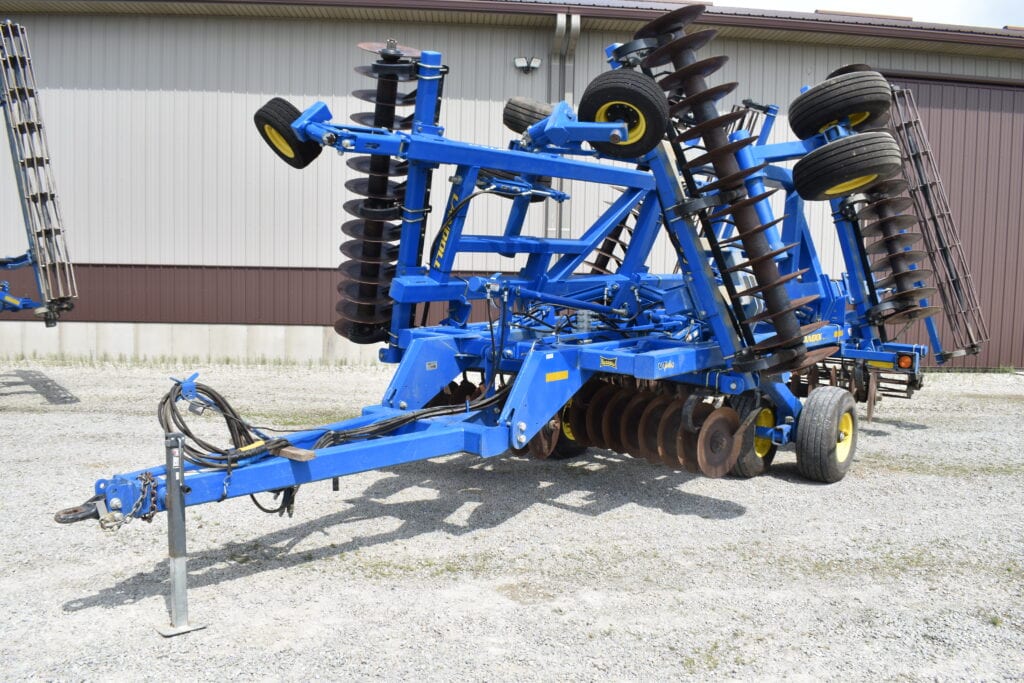 Blue disc harrow for farming at auction site.
