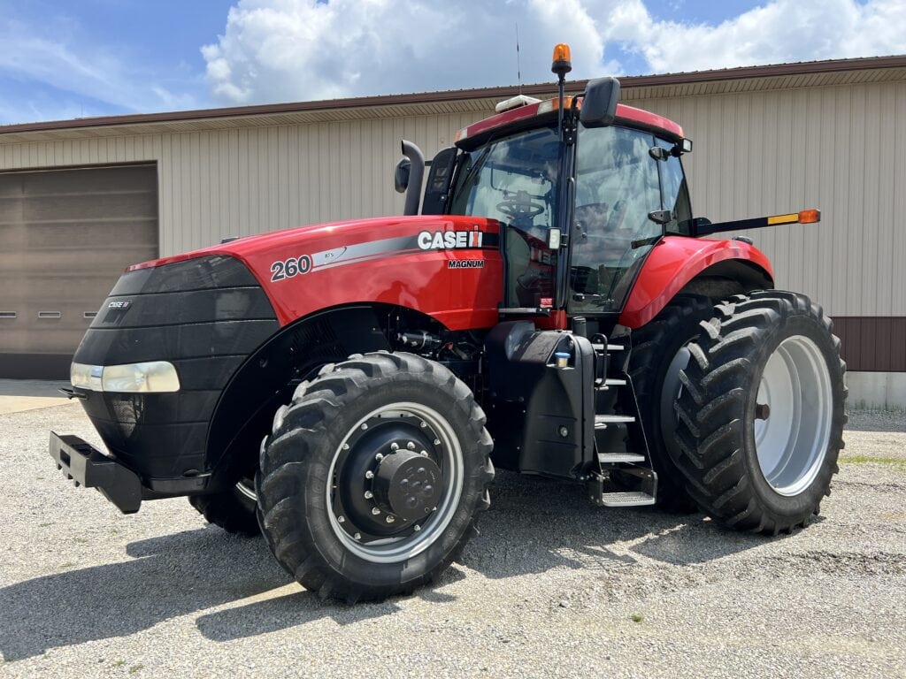 Red Case IH tractor with large tires at a farm auction.