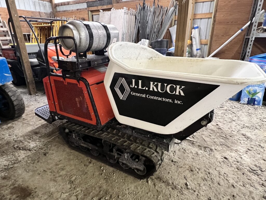 Small construction mini excavator with tracks and a white bucket.