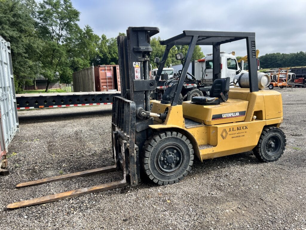 Yellow forklift with black forks at auction yard, J.L. Kuck.