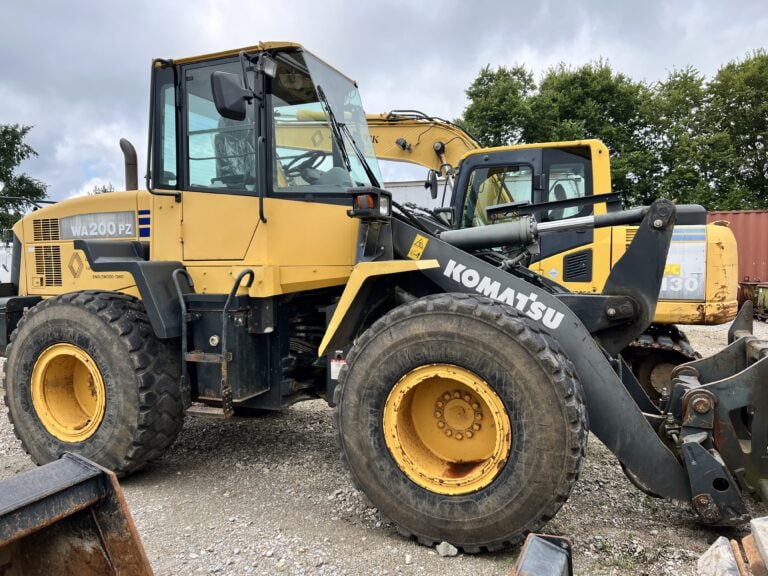 Yellow Komatsu WA200PZ wheel loader at auction site.