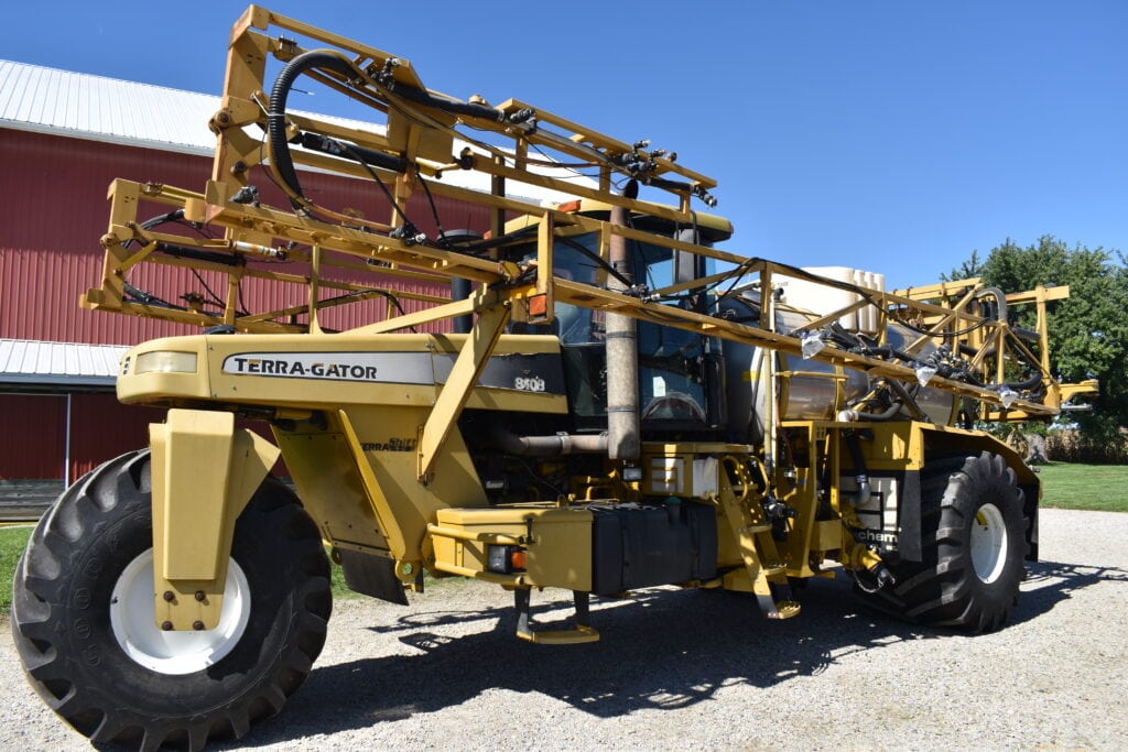 Large yellow Terra-Gator agricultural sprayer at a farm auction.