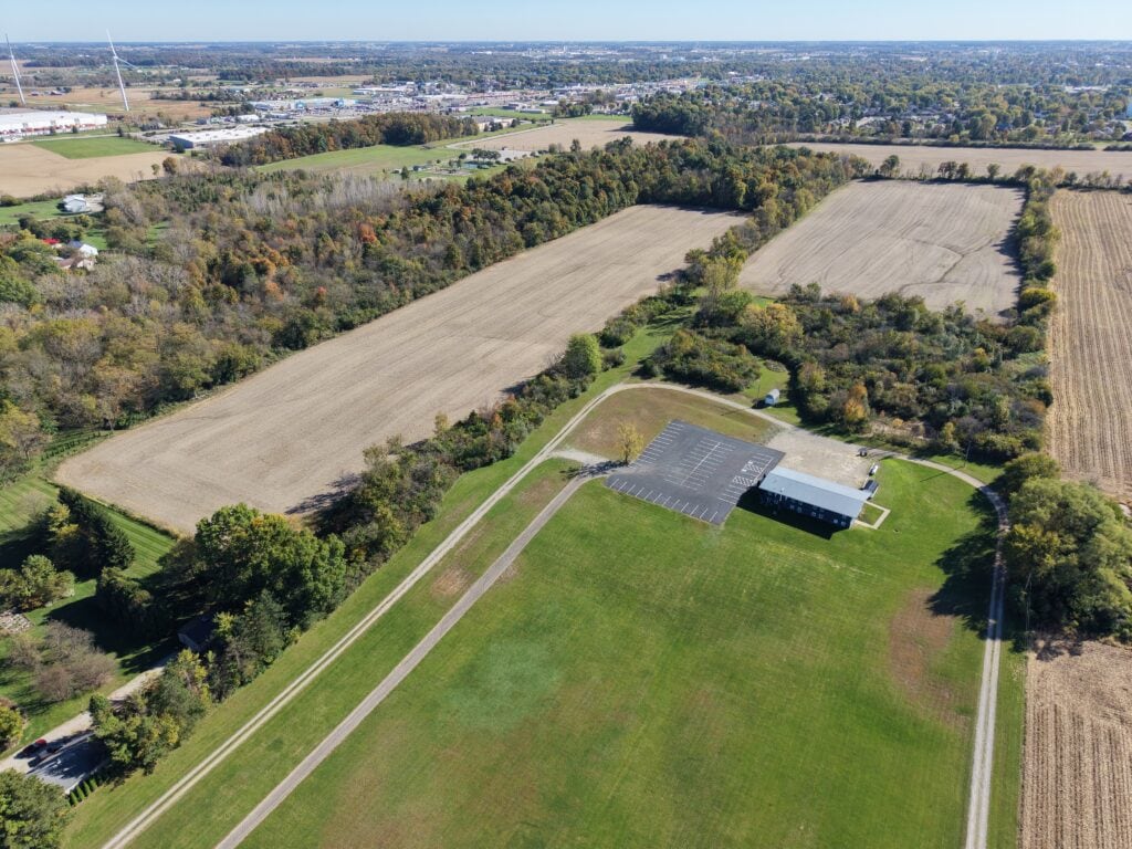 Aerial view of farmland and a large barn during daytime.