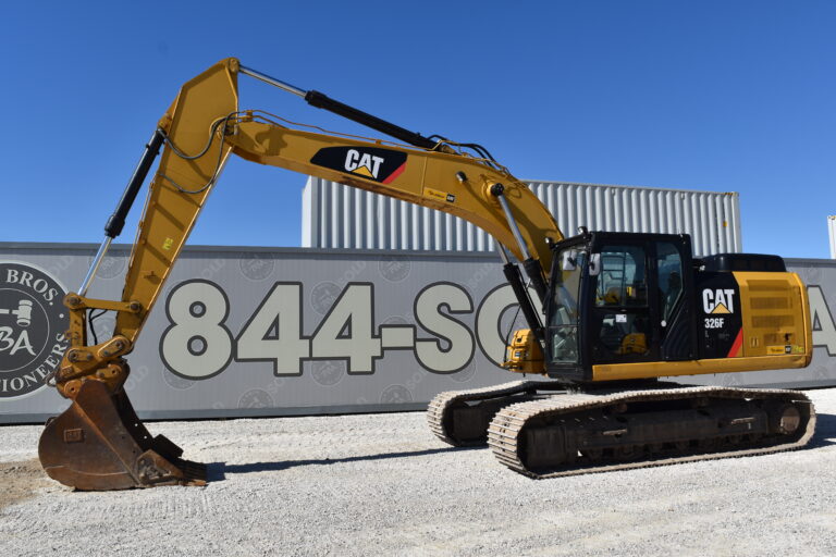 Yellow CAT 326F excavator on gravel lot at Bussey Bros Auctioneers.