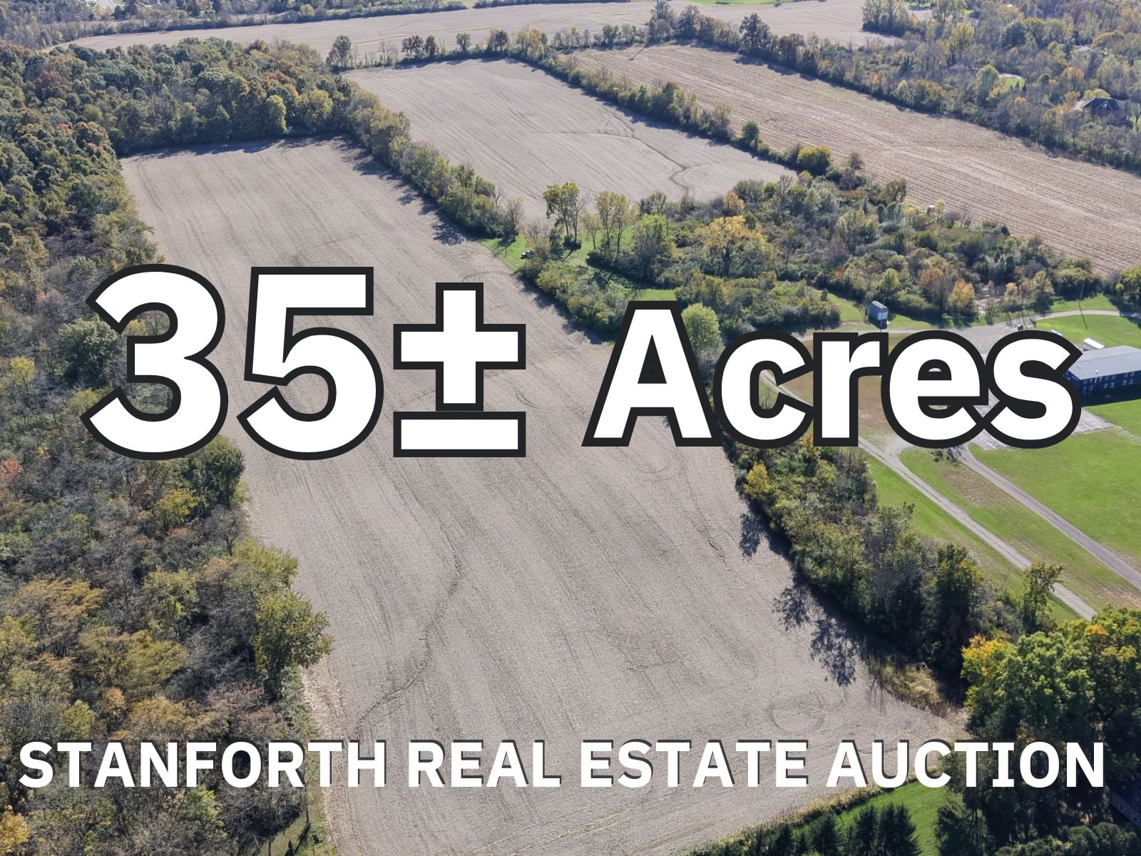 Aerial view of 35+ acres of farmland with fields and trees in a rural area.