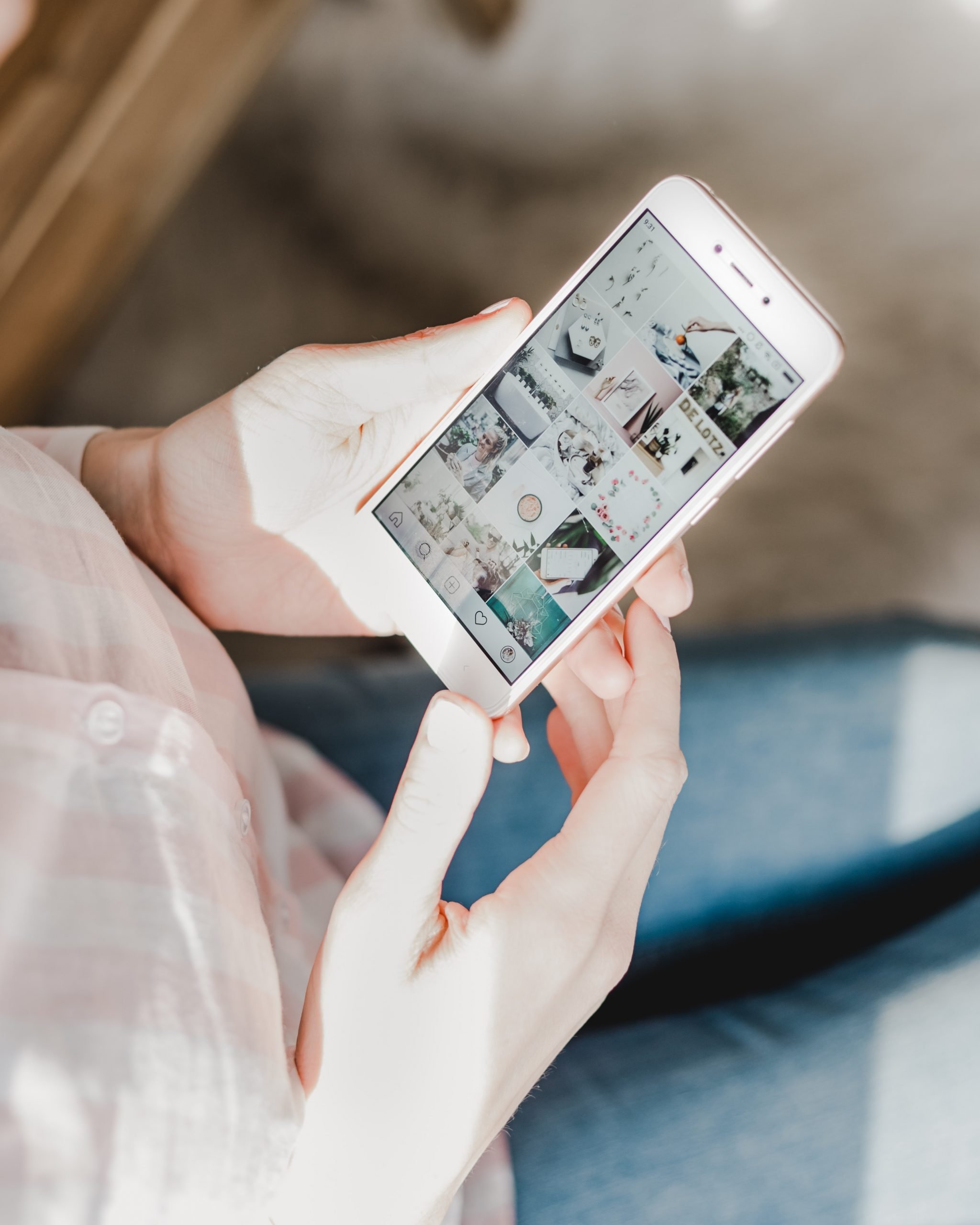 A photograph of a women holding a smartphone with Instagram open