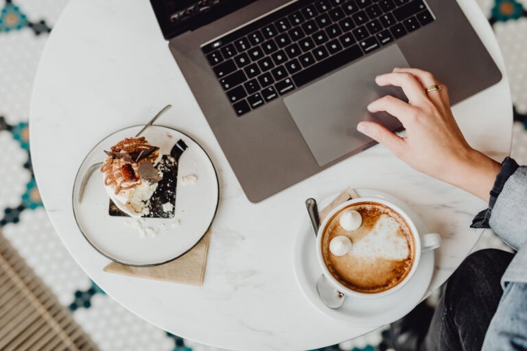 a person using a laptop and a cup of coffee