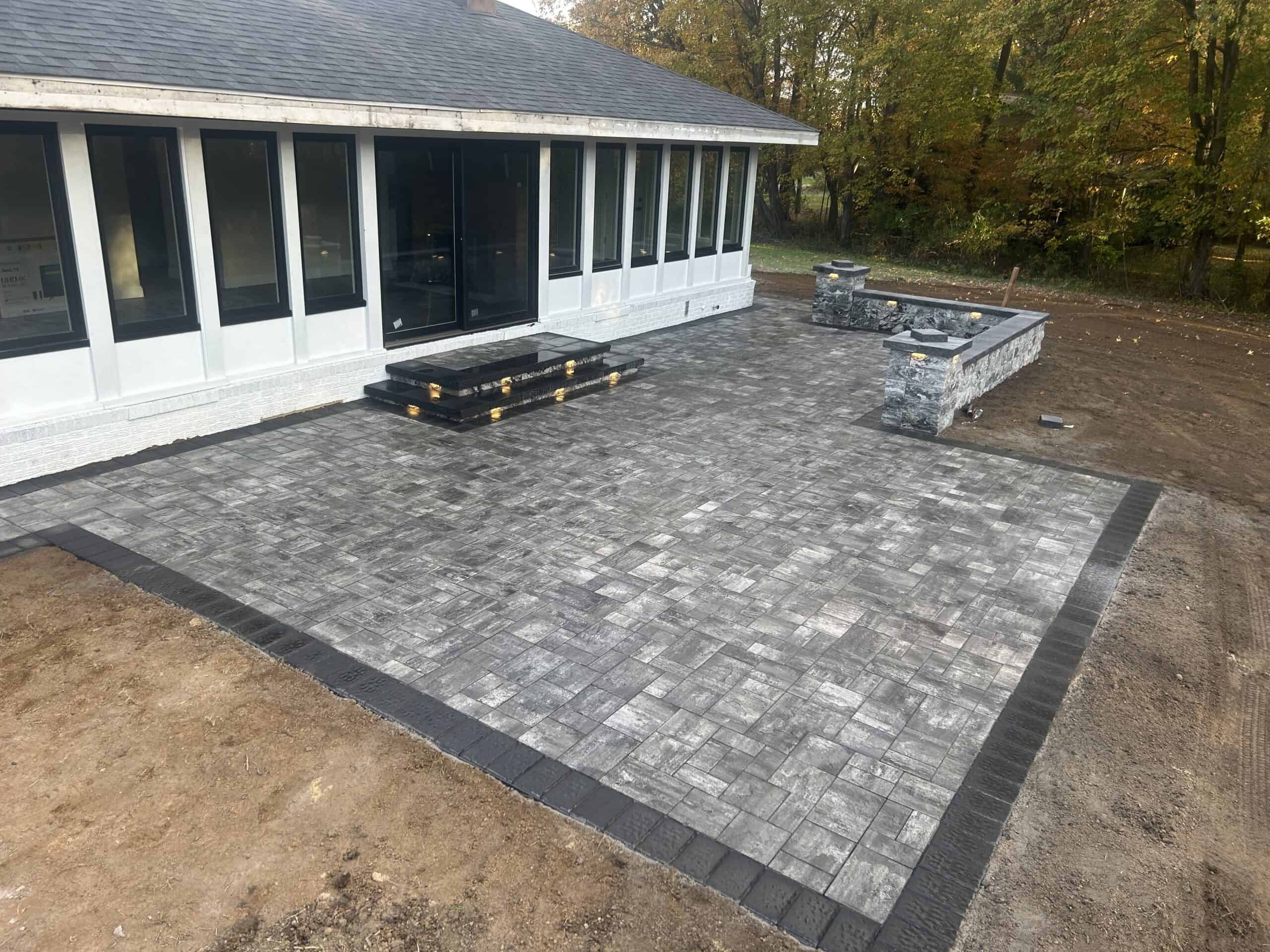 Paver patio with stone border and fire pit area, perfect for outdoor gatherings and relaxation.