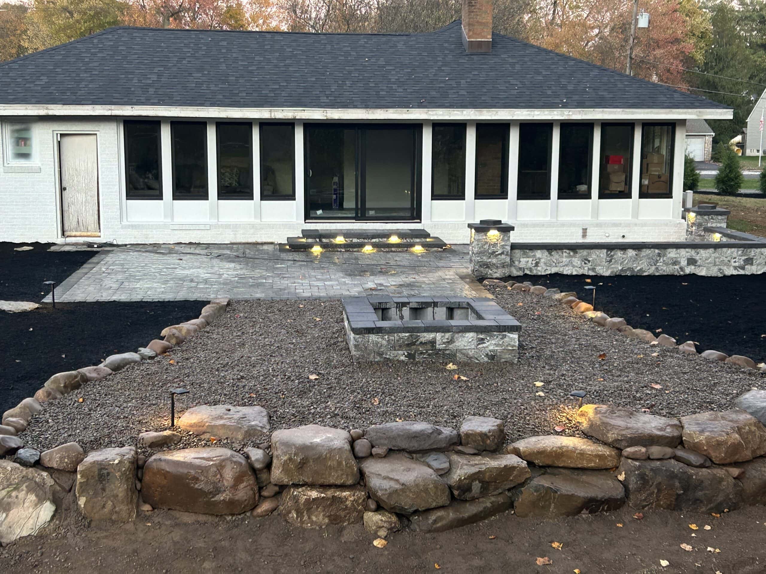 Garden landscape with stone border and pathway under construction.