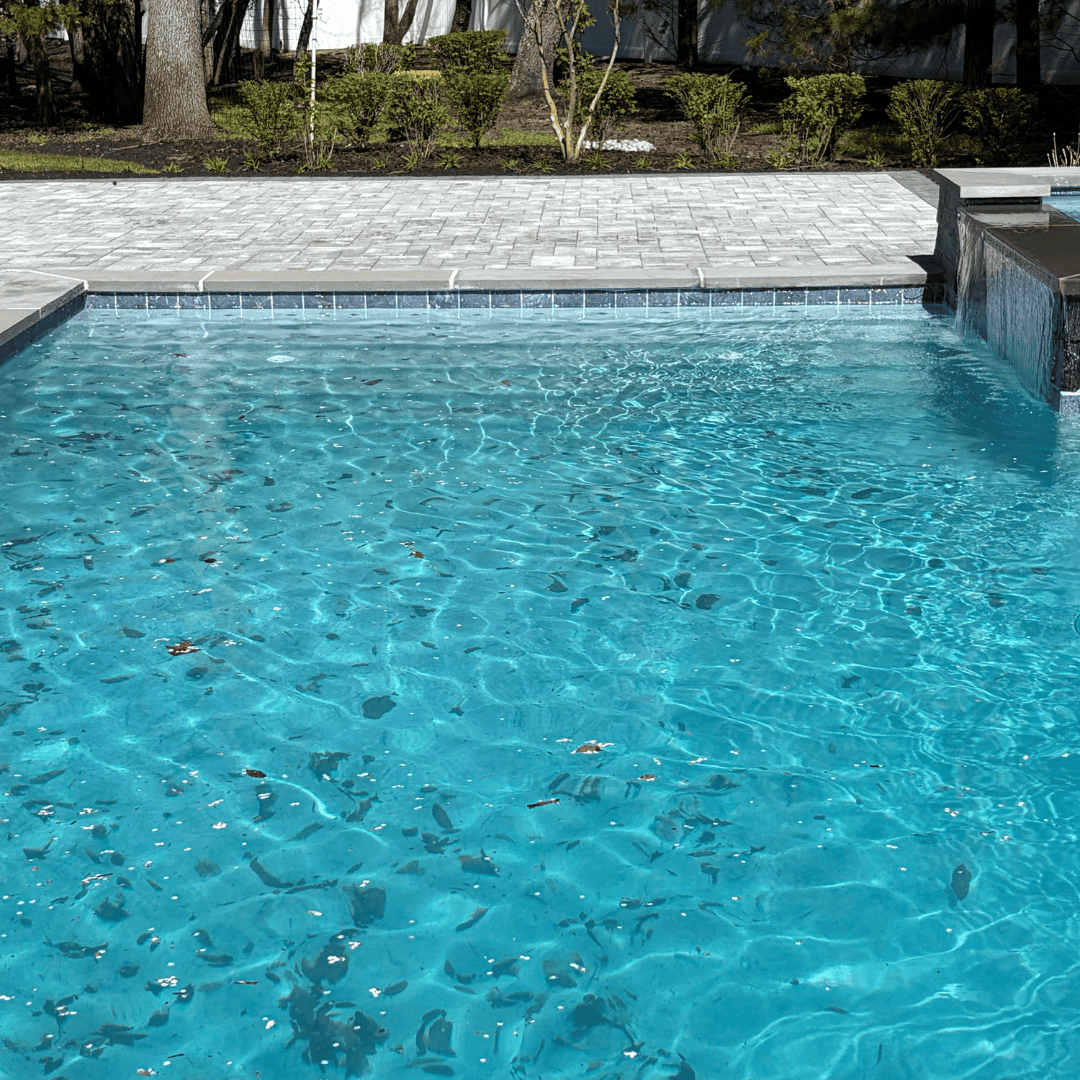 Professional pool cleaning and maintenance by C&J Outdoor Services in residential backyard.