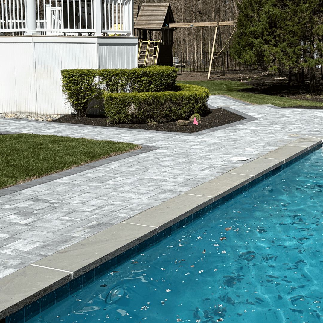 Poolside landscaping and patio installation by C&J Outdoor Services. Expert outdoor space design and.