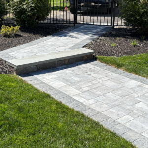 Stone walkway and steps with landscaping and gate at C&J Outdoor Services.