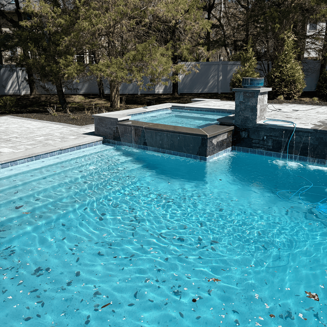 Custom backyard pool with spa and waterfall, expertly maintained by C&J Outdoor Services.