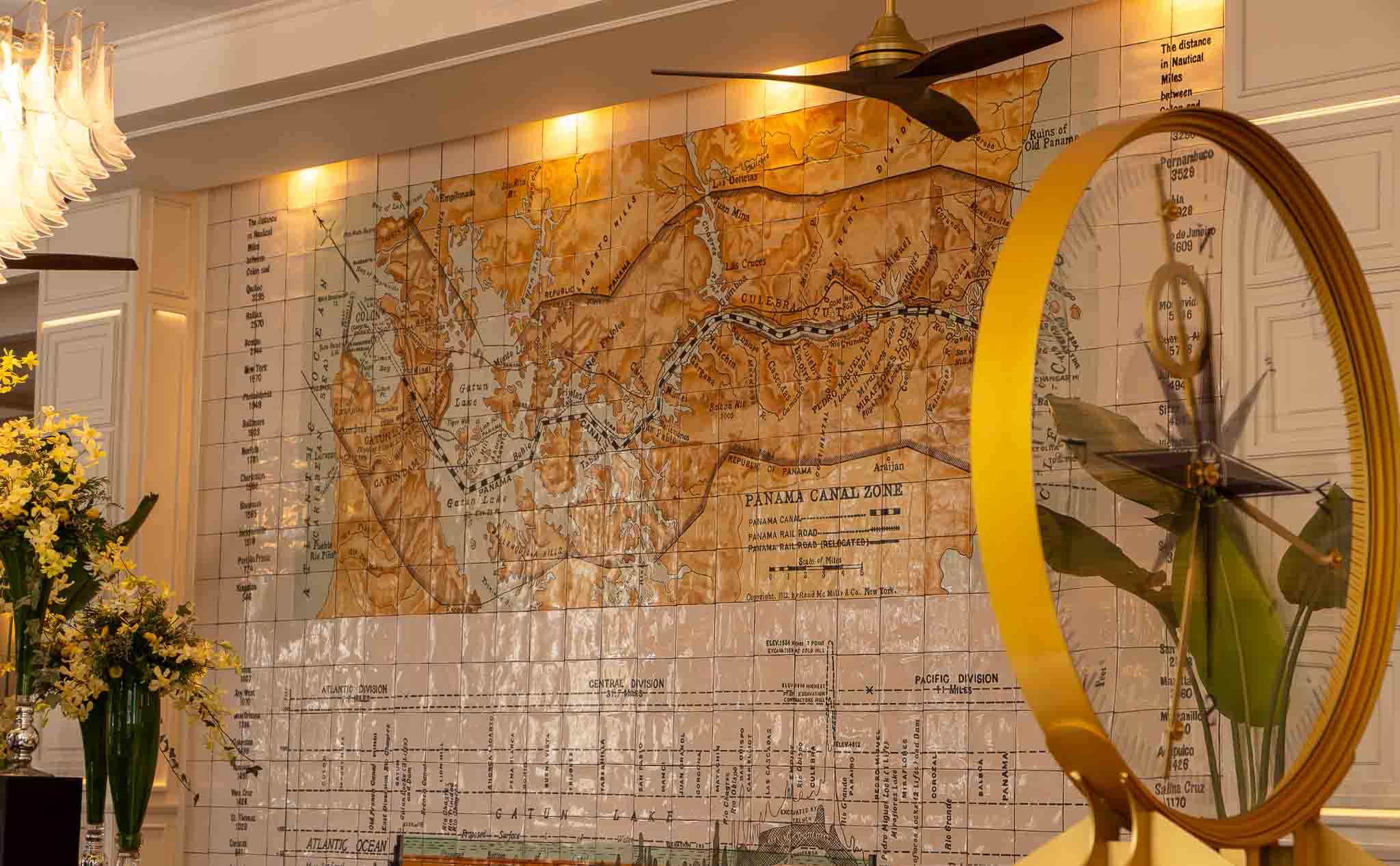 Sofitel Casco Viejo interior featuring a historic Panama Canal Zone tile map and golden compass sculpture in the lobby
