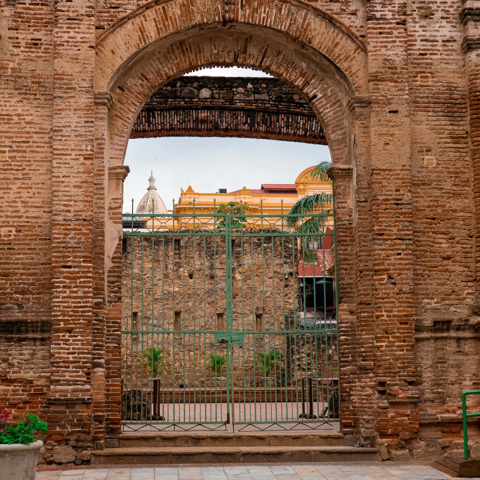 View through the Flat Arch in Casco Viejo, Panama, framing the cathedral dome and colonial walls — a favorite wedding and photo spot.