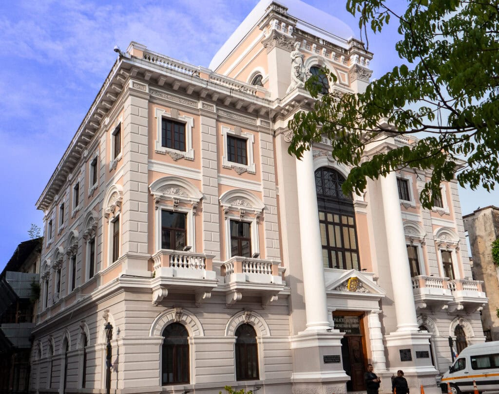 Elegant neoclassical façade of Palacio Bolívar in Casco Viejo, Panama, home to the Ministry of Foreign Affairs, with intricate columns and pink stone detailing.