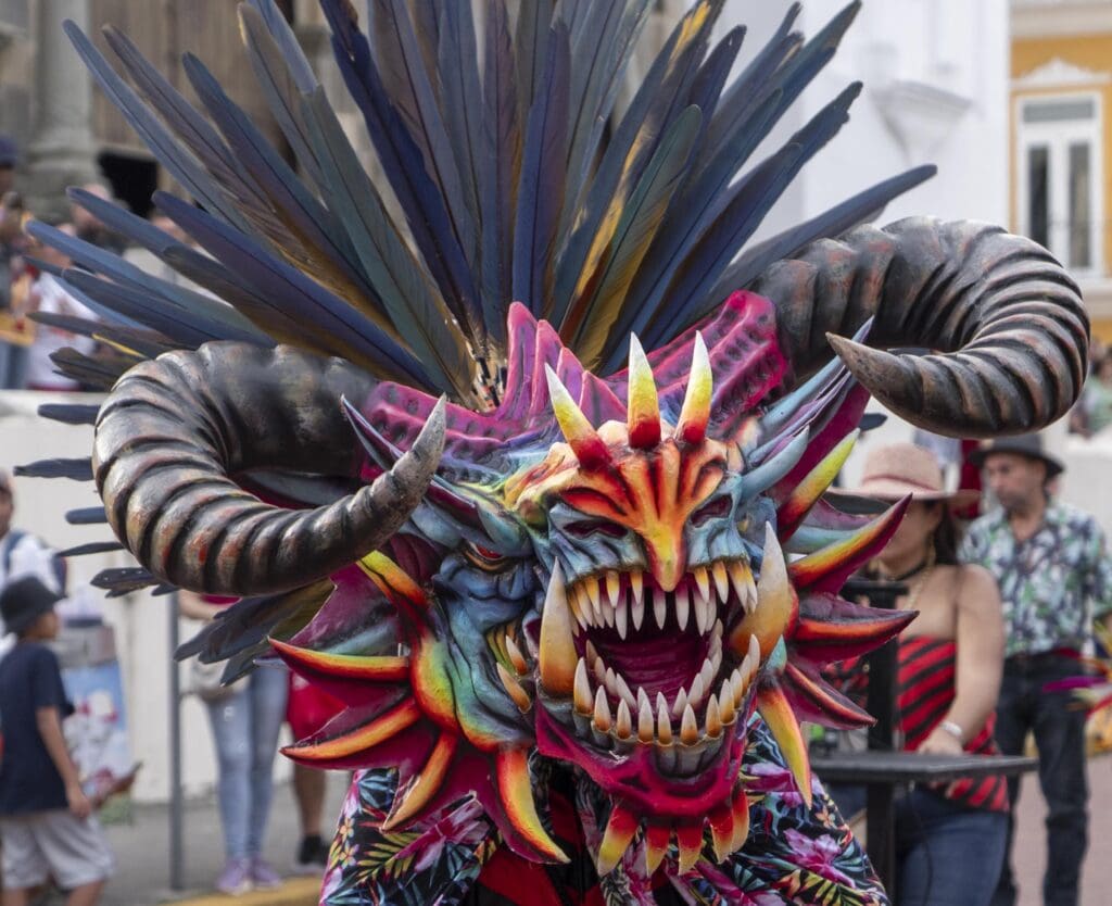 Colorful Diablico Sucio mask with purple and orange tones during a street festival in Casco Viejo Panama