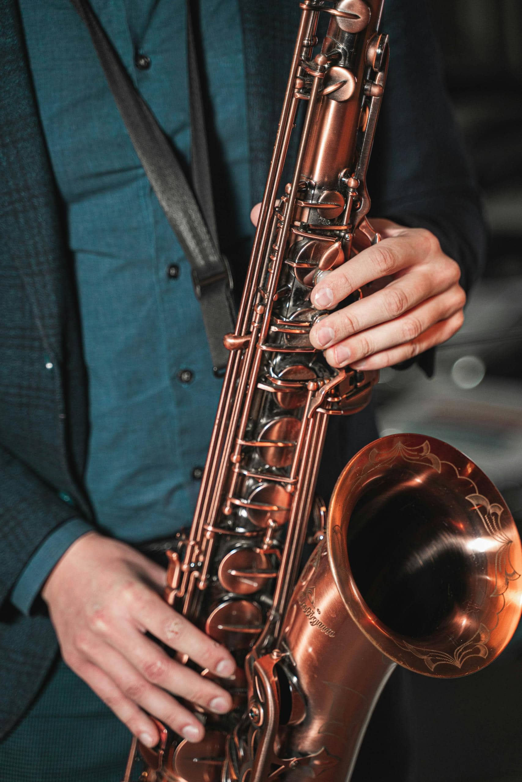 Close-up of hands playing a saxophone at a jazz festival, highlighting the instrument’s detail and craftsmanship