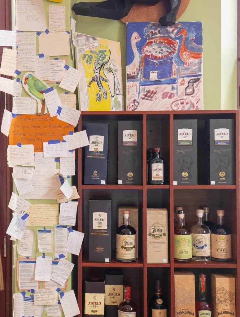 Shelf of Panamanian spirits and community poetry wall at Super Gourmet in Casco Viejo