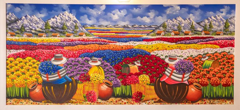 Colorful backdrop painting at Enkai Restaurant in Casco Viejo, Panama, featuring vivid flowers and traditional figures.