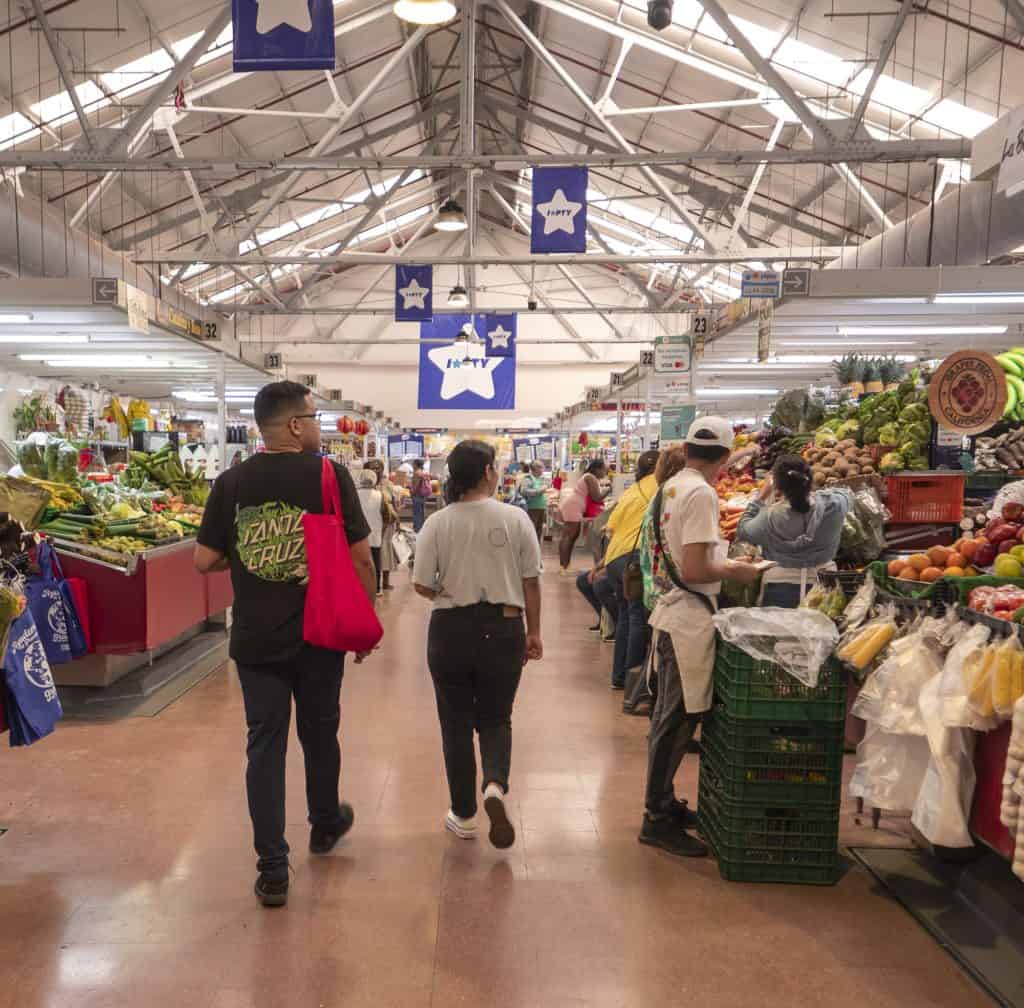 Chefs Ericka Rodriguez and Carlos H. Smith Q. walking into the fruit and vegetable market near Casco Viejo, Panama City, to buy fresh ingredients.
