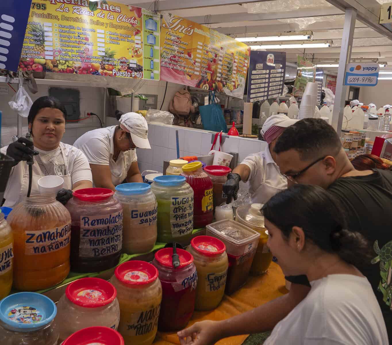 Vendors serving colorful fruit and vegetable juices at the market near Casco Viejo, Panama City.