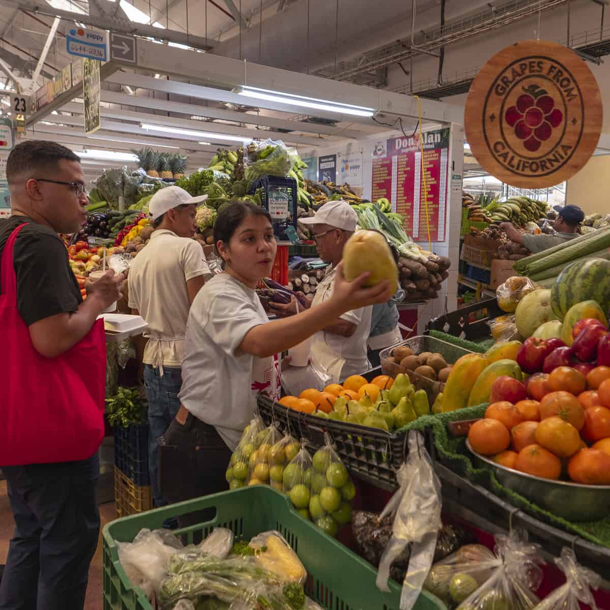 Chefs Ericka Rodriguez and Carlos H. Smith Q. selecting tropical fruits at the market near Casco Viejo, Panama City.
