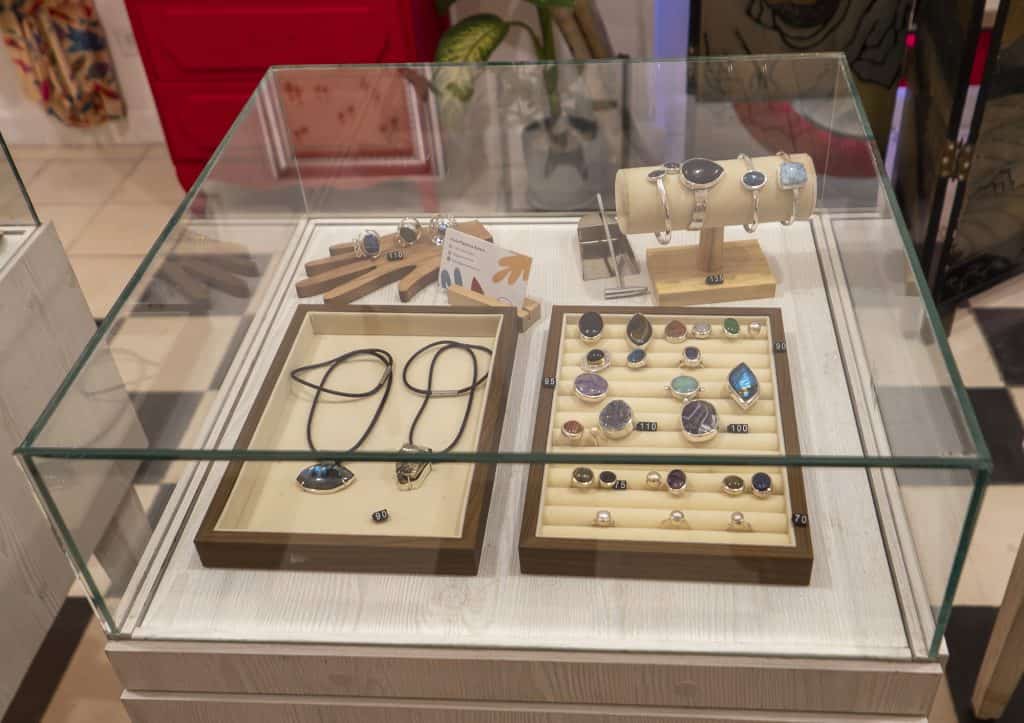 Glass jewelry display case at Arco Soleil in Casco Viejo, showcasing handmade artisan rings, necklaces, and gemstones.