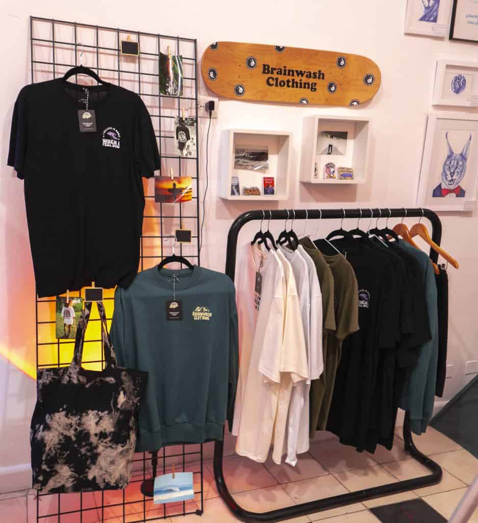 Brainwash Clothing retail wall in Casco Viejo with skate art, shirts, sweatshirts, and accessories on display.
