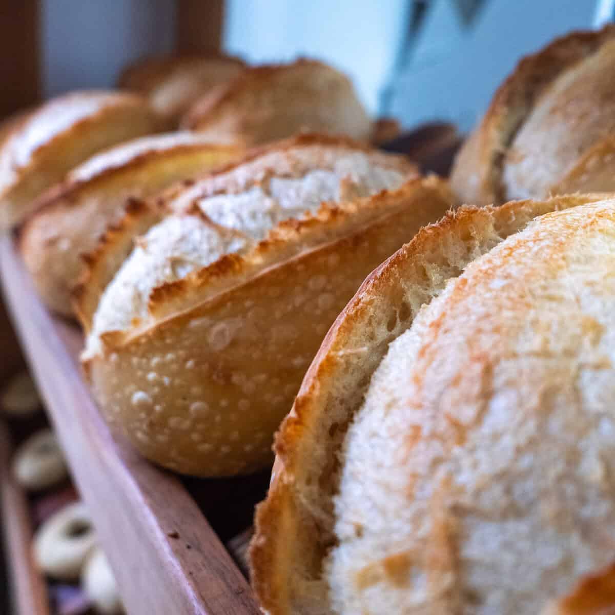 Freshly baked sourdough loaves resting in a wooden tray inside a small Casco Viejo bakery.