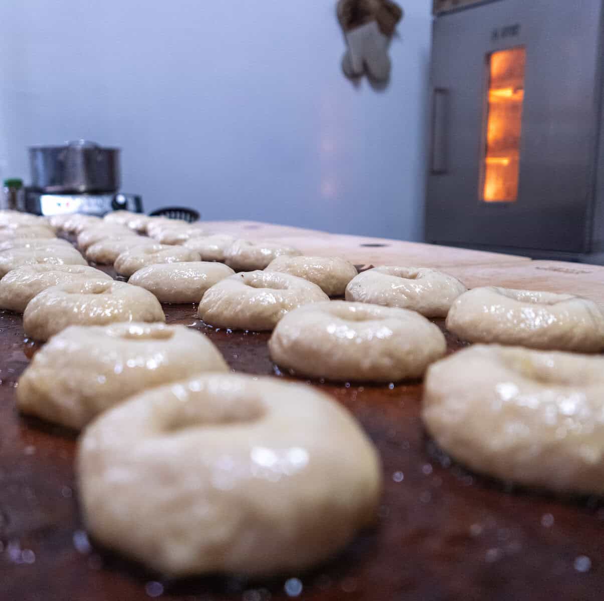 Rows of hand-shaped dough resting on a wooden board inside the small Casco Viejo bakery, ready for baking.