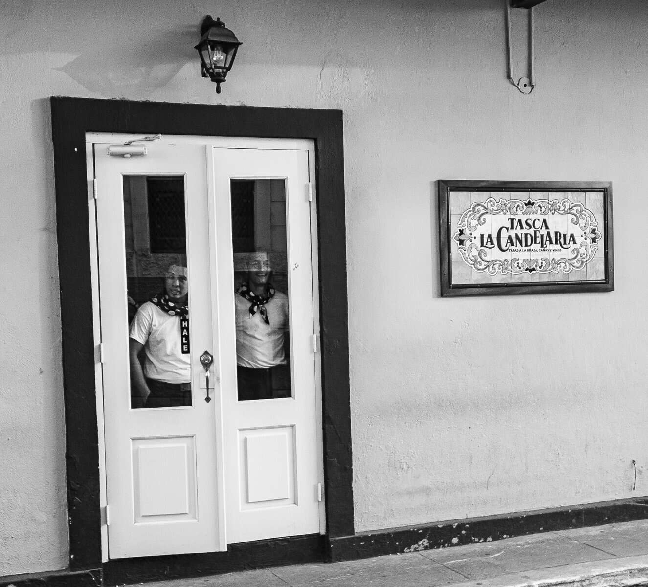 Two restaurant staff standing inside a doorway in Casco Viejo at the start of their shift